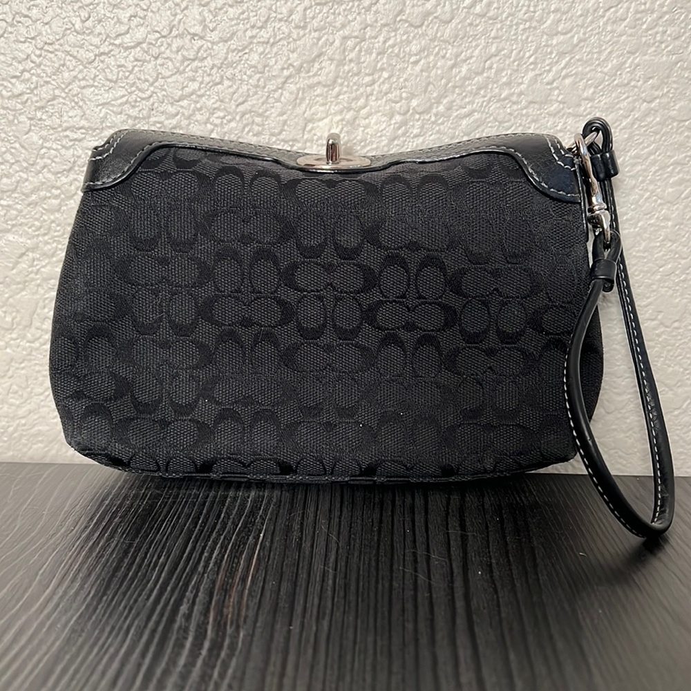 Coach black jacquard wristlet with leather closure and white stitching